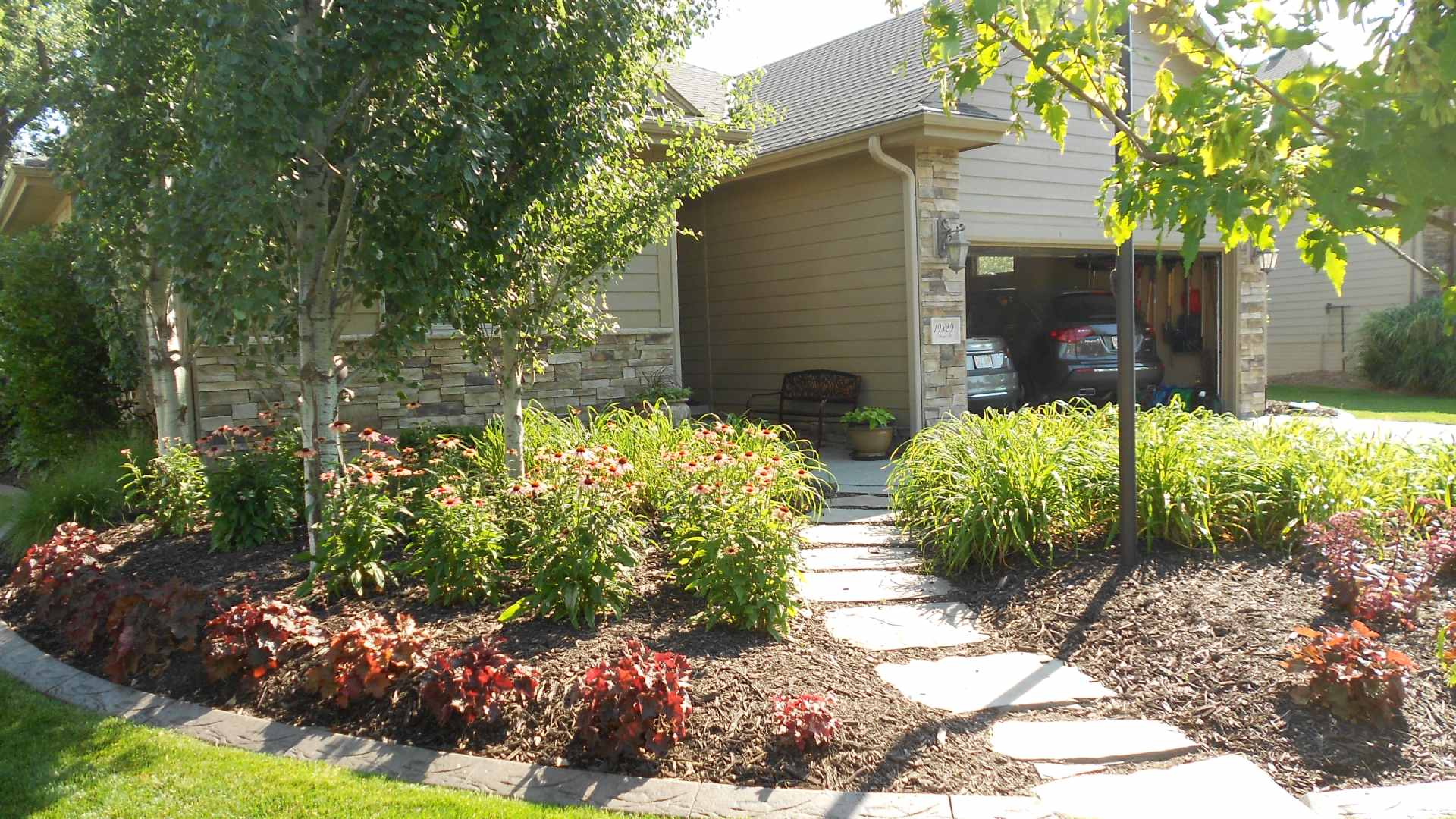 Home front with landscaping installed and walkway to yard in Ralston, NE.