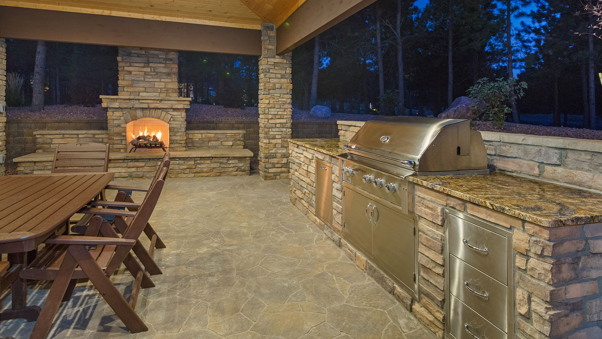 An outdoor kitchen installed with a fireplace behind a home in Bennington, NE.