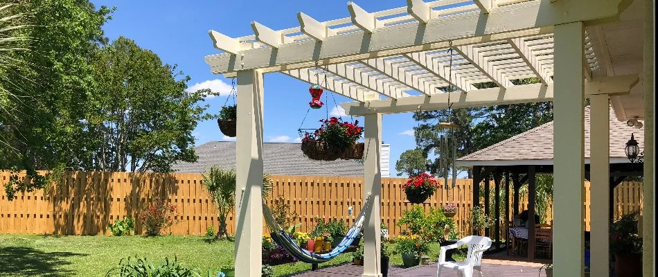 Wooden white pergola in Omaha, NE, with a swing on an outdoor space.