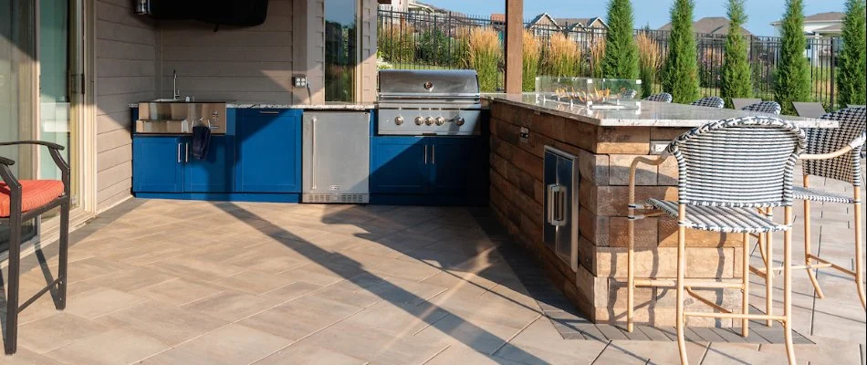 Outdoor kitchen with a grill and fire table in Omaha, NE.