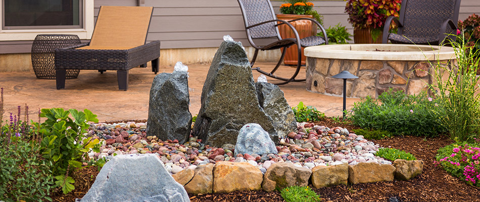 Three rock bubblers grouped together by a patio in Council Bluffs, IA. 