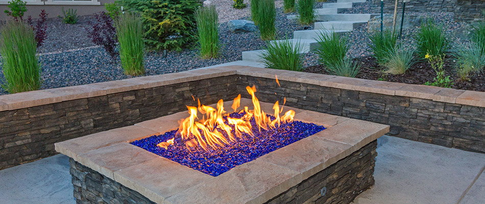 A retaining wall installed for both beauty and functionality around a fire table behind a home in Bellevue, NE. 