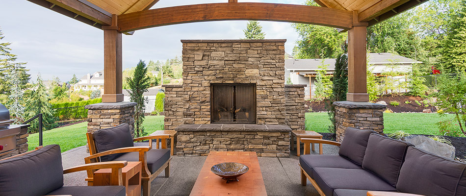 A stone fireplace built under a pavilion in a backyard in Bennington, NE. 