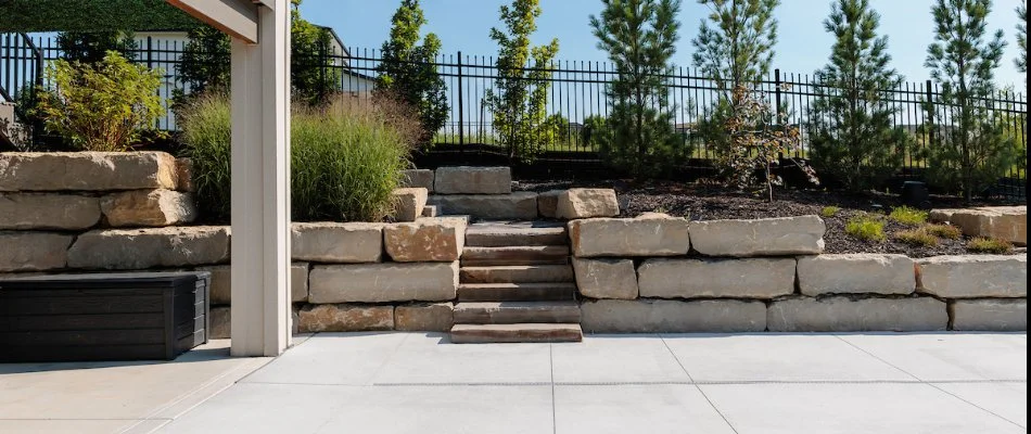 A stone retaining wall in Elkhorn, NE, with steps and landscape.