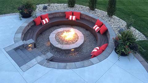 Fire pit with custom seating walls around it in Omaha, NE.