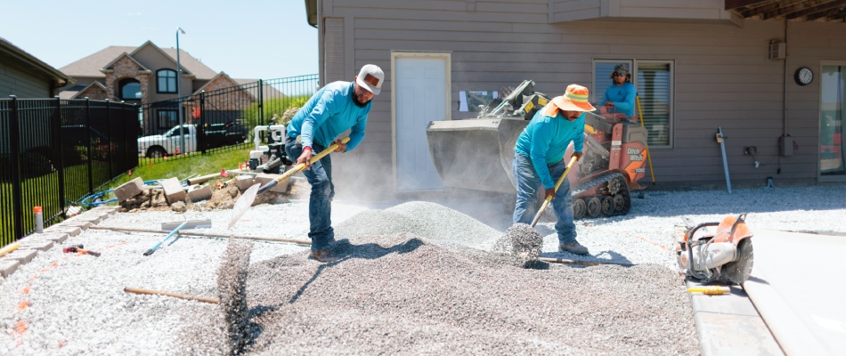 Workers spreading gravel around for project in Omaha, NE.